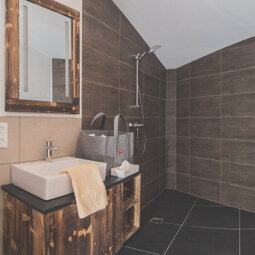 Il bagno è dotato di un lavabo in legno tirolese maturo a mano.